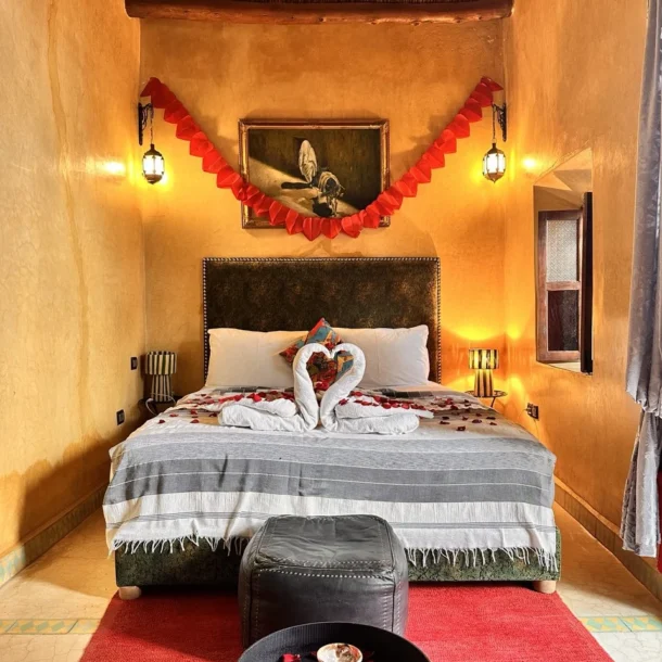 Romantic-Moroccan-riad-bedroom-with-decorated-double-bed_-rose-petals_-warm-lighting_-and-traditiona