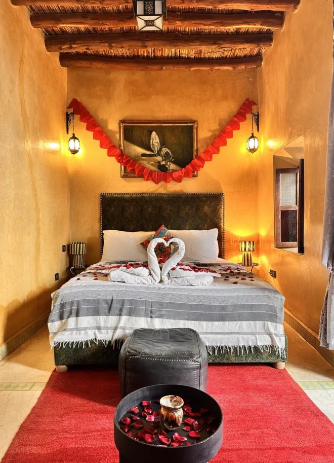 Romantic-Moroccan-riad-bedroom-with-decorated-double-bed_-rose-petals_-warm-lighting_-and-traditiona