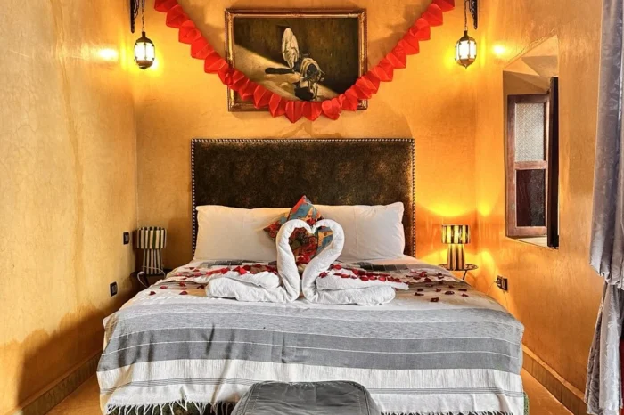 Romantic-Moroccan-riad-bedroom-with-decorated-double-bed_-rose-petals_-warm-lighting_-and-traditiona